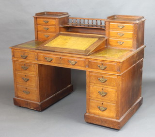 A Victorian oak Dickens style desk, the upper section with raised back and bobbin turned decoration above a recess with fall front beneath, flanked by 2 pedestals with three-quarter gallery fitted 6 drawers, the base fitted 1 long and 8 short drawers 103cm h x 138cm l x 71cm d