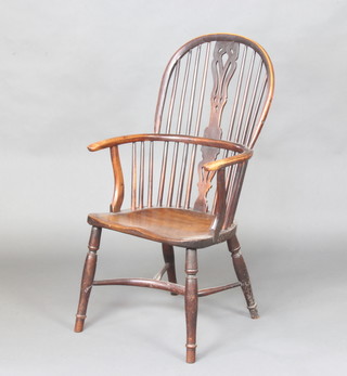 A 19th Century elm and yew hoop back Windsor kitchen chair with solid seat, turned supports and crinoline stretcher
