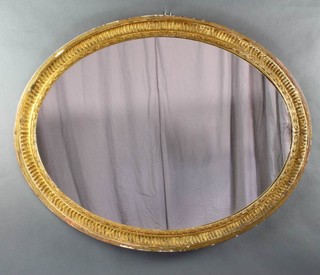 An oval plate wall mirror contained in a decorative gilt frame 72cm h x 97cm 