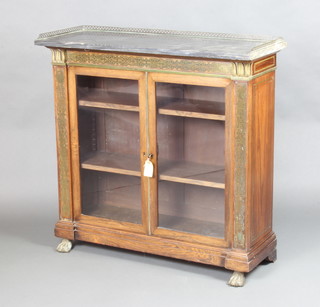 A Regency inlaid rosewood and brass display/bookcase the upper section with black veined marble top and brass pierced 3/4 gallery, fitted adjustable shelves enclosed by glazed panelled doors, the aprons inlaid brass, raised on paw feet 95cm h x 98cm w x 38cm d 