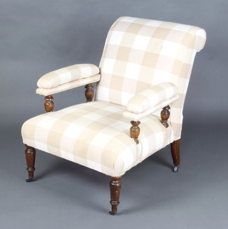 A Victorian Howard style mahogany framed open arm chair raised on turned supports upholstered in light chequered material