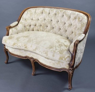A 19th Century style French show frame 2 seat sofa upholstered in light buttoned material, raised on cabriole supports 78cm x 110cm x 62cm