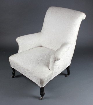A Victorian French armchair upholstered in white material raised on ebonised French cabriole supports 