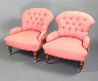 A pair of Victorian tub back chairs upholstered in pink buttoned material raised on turned supports 