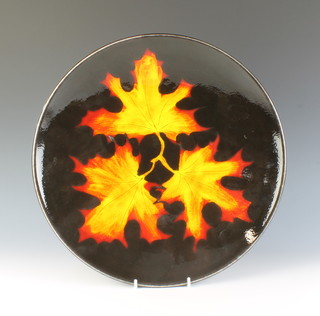 A Poole Pottery charger the black ground with 3 maple leaves 40cm  