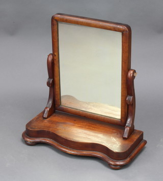 A Victorian arched plate dressing table mirror contained in a mahogany swing frame, the base of serpentine outline 50cm h x 51cm w x 23cm d