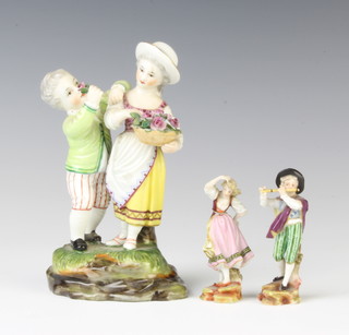 A late 19th Century German porcelain group of a young girl holding a basket of flowers with a young boy raised on a rocky base 13cm and a pair of ditto figures of a lady and gentleman 6cm 