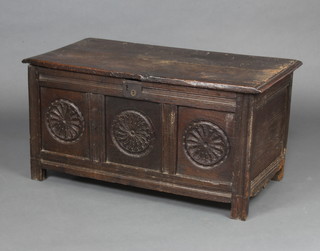 A 17th/18th Century style oak coffer of panelled construction with hinged lid and carved round decoration to the front panel 49cm x 97cm x 47cm