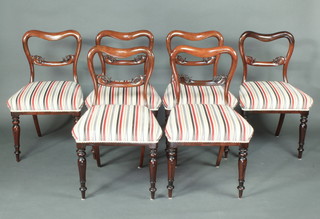 A set of 6 William IV rosewood spoon back dining chairs with carved mid rails and overstuffed seats raised on turned and fluted supports