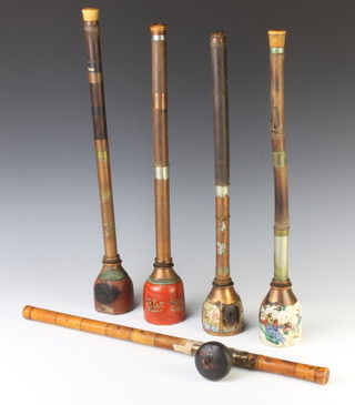 An early 20th Century famille rose opium pipe with copper mounts 50cm, a red ground ditto with stylised flowers and copper mounts 48cm, an earthenware opium pipe with copper mounts 53cm and 2 opium pipe stems, together with a famille rose base decorated with figures and metal mounts 19cm 