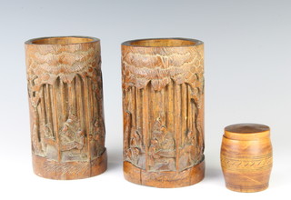 A turned wooden trinket box in the form of a barrel 6cm x 4cm and a pair of Chinese carved bamboo brush pots decorated figures 16cm x 9cm