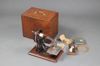 Wilcox and Gibbs, a manual sewing  machine complete with various attachments, a price list of Wilcox and Gibbs automatic silent sewing machine and a manual, contained in a mahogany case numbered A422875  