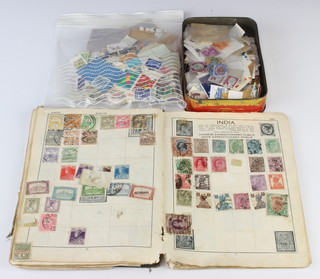 A 1930's album of used world stamps, a small collection of loose stamps contained in a tin 