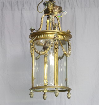 A cylindrical Adam style gilt metal hall lantern with swag decoration and bevelled glass panels to the sides 68cm h x 27 diam.  
