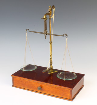 A set of brass and mahogany finished gold scales, the base fitted a drawer containing a set of polished steel and brass gold scales, a Salters no.2 spring balance and a collection of weights 
