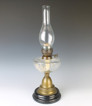 A 19th Century glass and gilt metal table lamp, the circular reservoir with panel cut decoration, raised on a gilt metal spreading foot complete with chimney 56cm x 19cm 