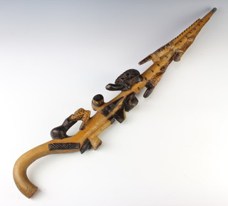 An African Nyami Nyami style carved wooden walking stick, carved serpent, tortoise, crocodile, 2 crossed pipes, lizards etc, the head is damaged 