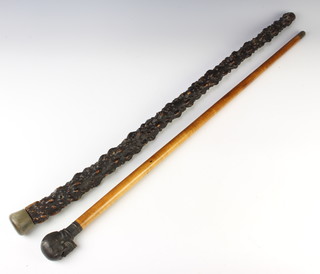 A malacca cane, the metal terminal in the form of a human skull together with a holly walking stick with horn handle 