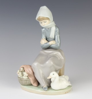 A Lladro group of a girl with basket of goslings and a goose at her feet 21cm 