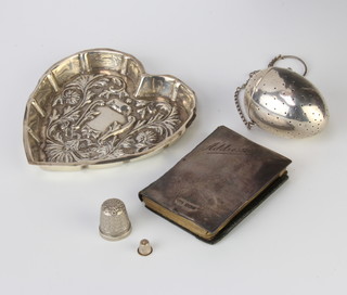 An Edwardian repousse silver heart shaped dish decorated with scrolls London 1901 maker Mappin & Webb together with a tea infuser, thimble and silver mounted address book, weighable silver 64 grams 