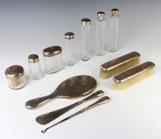 An Edwardian silver mounted toilet set comprising 7 mounted jars, a hand mirror, 2 clothes brushes, a shoe horn and button hook 