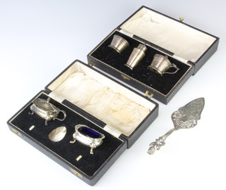 An Art Deco style silver 3 piece condiment Birmingham 1949, 2 other condiments and a cake slice, 234 grams 