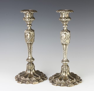 A pair of Victorian repousse silver candlesticks with vacant cartouches, 27cm 