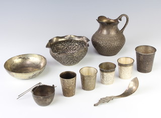 An Indian repousse silver jug, 4 tots, a beaker, bowl, dish, spoon and tea infuser, 520 grams