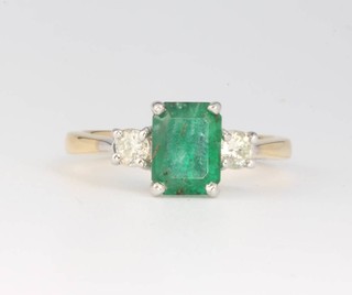 An 18ct yellow gold emerald and diamond ring, the emerald approx. 1.4ct flanked by brilliant cut diamonds approx. 0.28ct, size M 