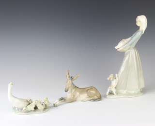 A Lladro group of a goose and goslings 11cm, a ditto of a reclining donkey 17cm and a goose girl 27cm 