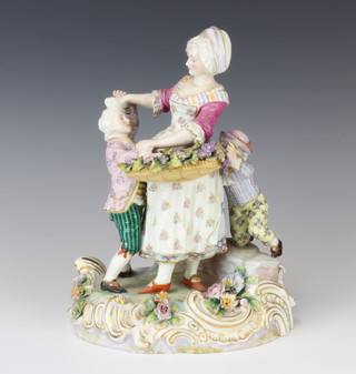 A late 19th Century German porcelain group of a lady holding a basket of grapes with 2 children at her feet, raised on a Rococo base 23cm 