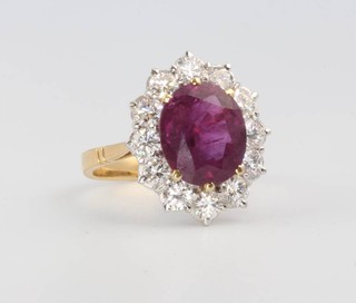 An 18ct yellow gold oval ruby and diamond cluster ring, the centre stone approx. 4ct surrounded by 12 brilliant cut diamonds, size M 
