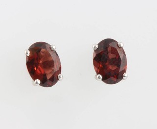 A pair of silver and garnet ear studs 
