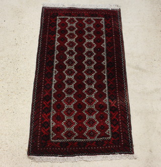 A black and red ground Afghan rug having numerous stylised octagons to the centre within a multi row border 194cm x 101cm 