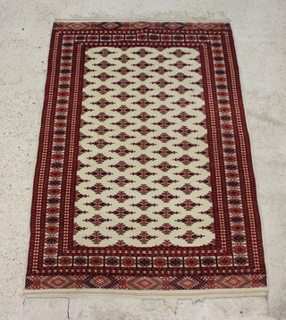 A white and red ground Bokhara rug with numerous stylised medallions to the centre within multi row border 193cm x 128cm 