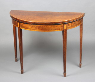 A Georgian inlaid mahogany demi-lune card table with crossbanded top raised on square tapered supports, spade feet 74cm x 96cm x 46cm 