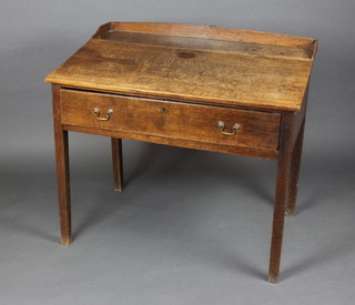 A 19th Century oak clerk's desk with 3/4 gallery fitted a drawer and raised on square tapered supports 92cm h x 104cm w x 69cm d 