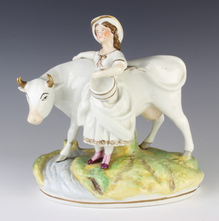 A Victorian Staffordshire figure of a milkmaid and cow on a raised base 20cm 