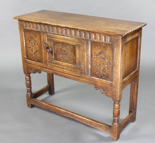 An Ipswich 17th Century style oak hutch cabinet fitted a cupboard with arcaded decoration enclosed by a panelled door and raised on turned and block supports 76cm h x 91cm w x 34cm d 