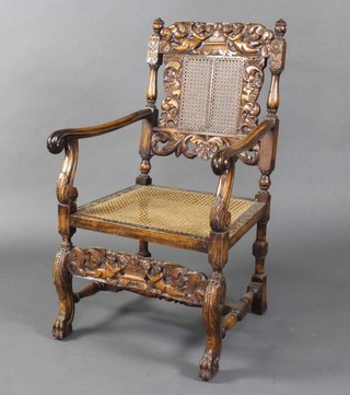 A carved and pierced oak Carolean style open arm chair, the carved cresting rail decorated cherubs and with woven cane seat, raised on cabriole supports with a turned box framed stretcher 
