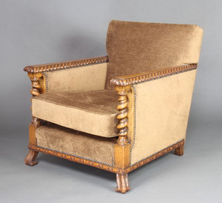 A 1930's Art Deco carved oak show frame armchair upholstered in brown buttoned Dralon 