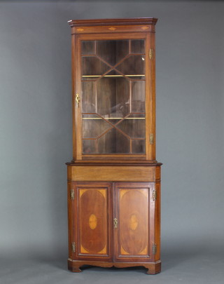 An Edwardian inlaid mahogany double corner cabinet, the upper section with moulded and dentil cornice, the interior fitted shelves enclosed by astragal glazed panelled doors, the base fitted a cupboard enclosed by inlaid panelled doors and raised on bracket feet 207cm h x 79cm w x 55cm d