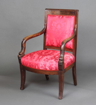 A Regency carved mahogany open armchair with upholstered seat and back and dolphin arms, raised on outswept supports