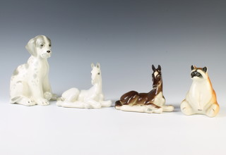 A Russian figure of a seated racoon 12cm, ditto reclining foal 11cm, a white ditto 10cm and a seated hound 16cm 