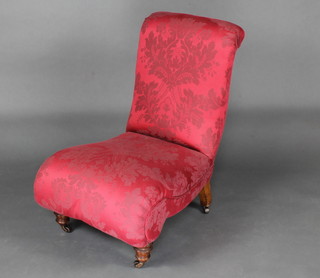 A Victorian nursing chair upholstered in red material raised on turned supports 