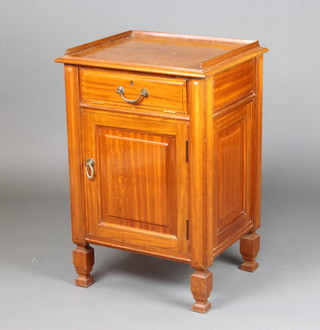 An Edwardian walnut bedside cabinet with 3/4 gallery fitted a fall front and a cupboard enclosed by panelled doors, raised on square supports 77cm x 52cm x 44cm 
