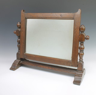 A rectangular bevelled plate dressing table mirror contained in an oak frame with turned and block decoration 36cm h x 54cm w x 21cm d 