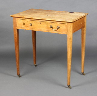 An Edwardian light oak writing table  with pen and inkwell recess, fitted 1 long drawer with brass swan neck drop handle, raised on square tapered supports ending in brass caps and casters 76cm h x 75cm w x 46cm d (1 handle missing) 