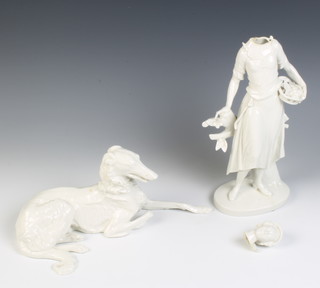 A Nymphenburg white glazed figure of a reclining hound 28cm, a Continental white glazed figure of a lady fruit seller 27cm 