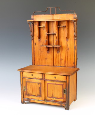 A 19th Century Continental pine dolls house dresser with raised back, the base fitted 2 drawers above a cupboard enclosed by sliding doors 44cm x 26cm x 14cm 